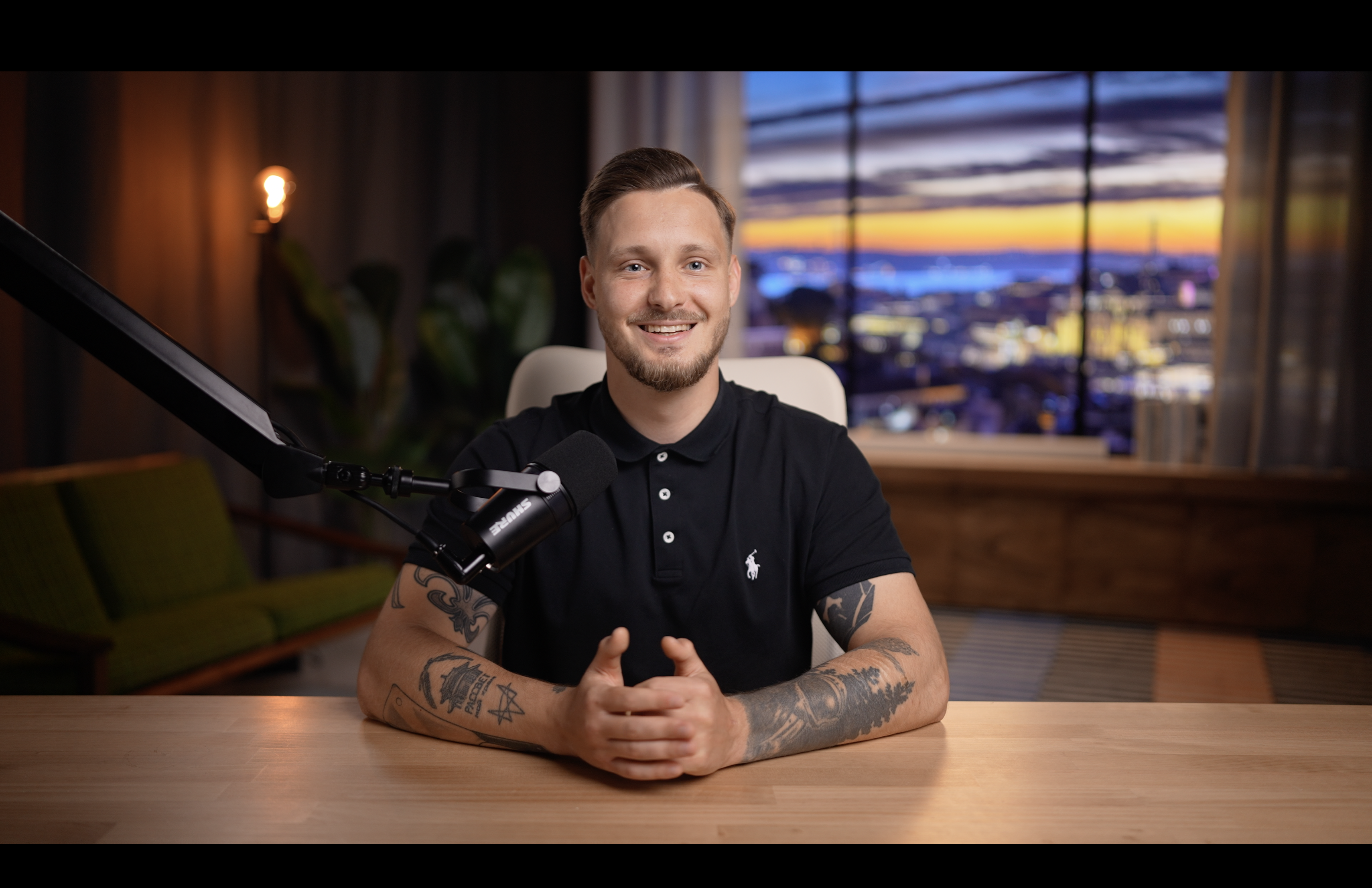 George Helgesen at the Backstage Tech podcast desk, Oslo skyline at dusk behind him